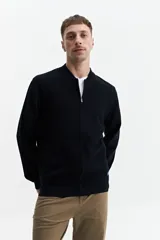 Campera tejida de punto color beige, con cuello rib, puños y bolsillos laterales.