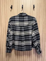 Camisa de franela escocesa en tonos bordó, negro y crudo, con cuello con pins sorpresa y cierre frontal oculto con botones.