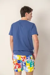 Remera azul con logo de pájaro bordado en el pecho, corte clásico y mangas cortas.