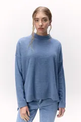 Sweater de lana color crema, de cuello alto y corte holgado.