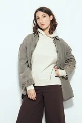 Canguro negro de silueta amplia con capucha integrada y detalles de líneas blancas que recorren el frente y las mangas.