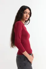 Remera de manga larga con cuello redondo a la base, confeccionada en algodón, de corte ajustado al cuerpo.