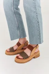 Sandalias de plataforma con suela track, combinando cuero marrón, gamuza y detalles en textura reptil. Cuentan con tira ajustable en el tobillo y diseño ergonómico.