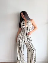 Pantalón de pierna ancha con estampado de rayas verticales negras sobre fondo crudo, confeccionado en tela slab con cintura elástica.