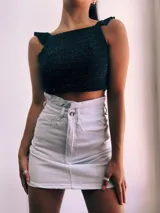 Crop top negro con textura brillante, breteles anchos con volados y espalda descubierta que se ata con lazos.