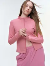 Campera deportiva de cuello alto con cierre frontal de doble cursor. Presenta un corte ajustado que realza la silueta, bolsillos laterales con cierre y mangas largas con puños con abertura para el pulgar.