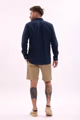 Bermuda color marrón confeccionada en lino, de corte recto y largo a la rodilla.