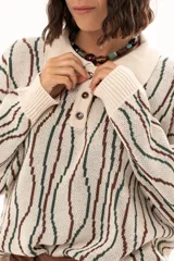 Buzo de tejido de punto con diseño de rayas verticales onduladas en tonos verde y marrón sobre base color crudo. Presenta cuello tipo polo con cierre frontal de botones y mangas largas con puños acanalados.