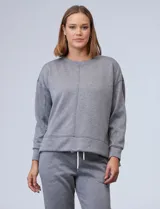 Buzo blanco de tejido elastizado, con pespunte central en la parte delantera y tajos laterales.