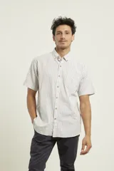 Camisa de manga corta a rayas verticales azules y blancas, con cuello abotonado y cierre frontal con botones marrones.