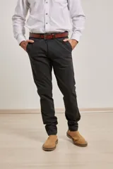 Pantalón de vestir verde oliva, de corte slim fit, sin pinzas, con bolsillos laterales y traseros. Se ajusta a la cintura con cinturón de cuero marrón.