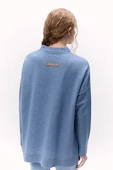 Sweater de lana color crema, de cuello alto y corte holgado.