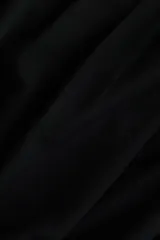 Top de manga larga con diseño drapeado, presenta pliegues en un hombro y en el lateral de la cintura, con ajuste entallado al cuerpo.