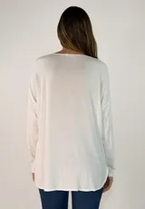 Blusa de satén color bordó, con escote en V, mangas largas y corte holgado.