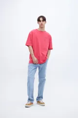 Remera gris con cuello redondo, mangas cortas y calce oversize. Presenta un pequeño estampado en el pecho y un bordado en la manga. Confeccionada en algodón lavado con textura extra suave y tela jersey pesado.