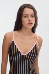 Malla enteriza de color off-white con estampado de lunares negros y vivos en contratono tostado. Presenta escote en V y tirantes finos.