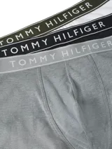 Pack de tres calzoncillos tipo trunk de Tommy Hilfiger, confeccionados en algodón elástico. Incluye un modelo blanco, uno negro y uno gris melange, todos con cintura elástica con el nombre de la marca estampado.