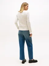 Sweater de manga larga con cuello barco y sutiles volantes en el borde. Presenta un diseño de rayas horizontales en tonos blanco y beige.