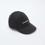 Gorra de béisbol negra con bordado frontal en color blanco que dice 'Casually Iconic'.