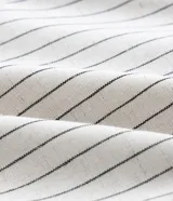Blusa sin mangas, estilo chaleco, confeccionada en viscolino con estampado de rayas verticales finas. Presenta escote en V con amarras ajustables en el centro del busto.