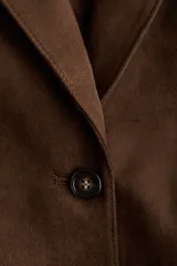 Blazer marrón de botonadura sencilla con acabado cepillado suave, hombreras, solapas de muesca y bolsillos delanteros ribeteados.