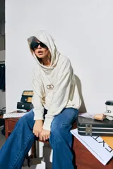 Canguro color crema de algodón, corte oversize, con capucha y logo bordado en el frente.