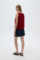 Musculosa de viscosa color beige claro, holgada, con cuello redondo y tirantes anchos formados por múltiples tiritas trenzadas.