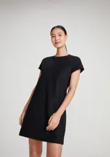 Vestido corto marrón de corte recto y holgado, con mangas cortas con vuelta, cuello redondo y un bolsillo aplicado en el pecho.