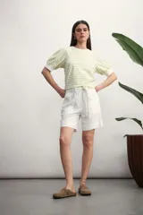 Remera de algodón con estampado de rayas horizontales en color verde claro sobre fondo blanco, con mangas cortas abullonadas y puños lisos.