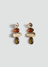 Aros colgantes formados por piezas metálicas doradas de diseño irregular y piedras de resina en tonos ámbar y marrón oscuro.
