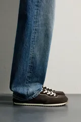 Zapatilla deportiva barefoot de hombre, confeccionada en combinación de piezas de piel con acabado serraje en color marrón, con cordones y suela fina de goma en contraste.