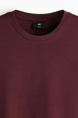 Remera de algodón liviano color bordó, con cuello redondo ribeteado y mangas cortas, de corte estándar.