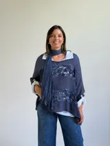 Sweater de punto azul con diseño holgado, que incorpora paneles de encaje floral en el frente y los laterales. Presenta un estilo superpuesto con cuello redondo y mangas largas con puños vueltos.