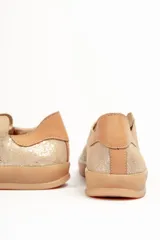 Zapatilla de cuero vacuno color rojo, con cordones al tono y suela de caucho color caramelo. Detalle de cuero vacuno color tostado en el talón.