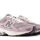 Championes urbanos New Balance modelo 2010, color rosado con detalles en gris y blanco. Confeccionados en una combinación de gamuza y malla, presentan el logo N característico en los laterales y una entresuela con tecnología de amortiguación visible en el talón.
