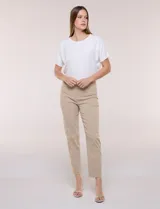 Pantalón color beige de corte entallado y largo cropped, confeccionado en tejido de punto con elasticidad técnica. Cuenta con pretina ancha y plana, bolsillos simulados al frente y bolsillos tipo ojal en la parte posterior.