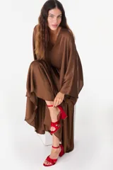 Sandalias rojas de cuero con diseño de nudo frontal, tira fina al tobillo con hebilla metálica y taco ancho estructurado.