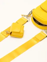 Bandolera amarilla con correa fina regulable y monedero colgante.