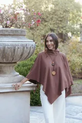 Poncho de textura suave tipo polar, color marrón, con cuello alto y diseño amplio de corte asimétrico.