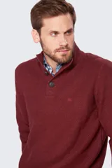 Buzo gris de tejido grueso con cuello alto y medio cierre con botones.