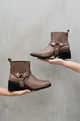 Bota corta de cuero vacuno color marrón con elásticos laterales, taco cuadrado y estribo desmontable.