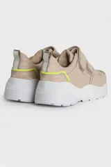 Zapatillas urbanas de cuero color beige con ajuste de velcro y suela blanca.