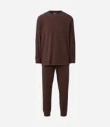 Pijama masculino de dos piezas confeccionado en tejido fleece texturizado. Incluye una remera de manga larga con cuello redondo y puños ajustados, y un pantalón tipo jogger con cintura elástica, cordón de ajuste y bolsillos laterales.