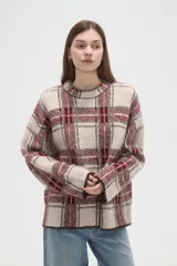Sweater de punto jacquard con diseño a cuadros en tonos beige y bordó, de corte holgado, cuello redondo y mangas largas.
