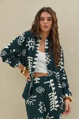 Camisa verde inglés con estampado abstracto en color blanco, de manga larga y cierre frontal con botones.