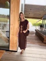 Vestido midi marrón oscuro de corte recto y mangas cortas, con cuello redondo adornado con costuras decorativas y rombos de cuero camel bordados en el frente. Cuenta con aberturas laterales con detalles de costura a contratono.