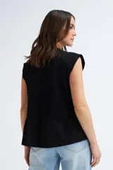 Camiseta sin mangas negra con cuello redondo, hombros estructurados y un volante peplum en la parte inferior.