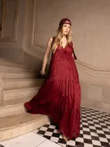 Vestido largo color marrón con bordados florales a tono, escote en V y corte imperio. Tiene falda amplia con volados y breteles finos.