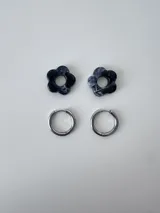 Aros de acero quirúrgico argolla con dije colgante en forma de flor de resina color gris marmoleado.