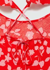 Vestido largo de viscosa con estampado floral en tonos rojos y rosados, escote redondo y tirantes finos con volados en los hombros.